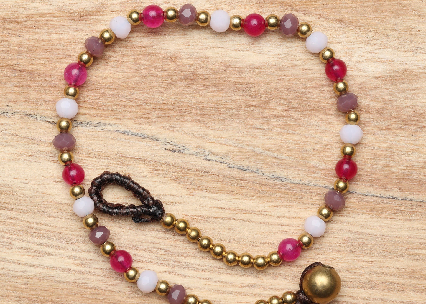A crystal healing bracelet made of faceted Moonstone crystals on a cotton cord with brass beads