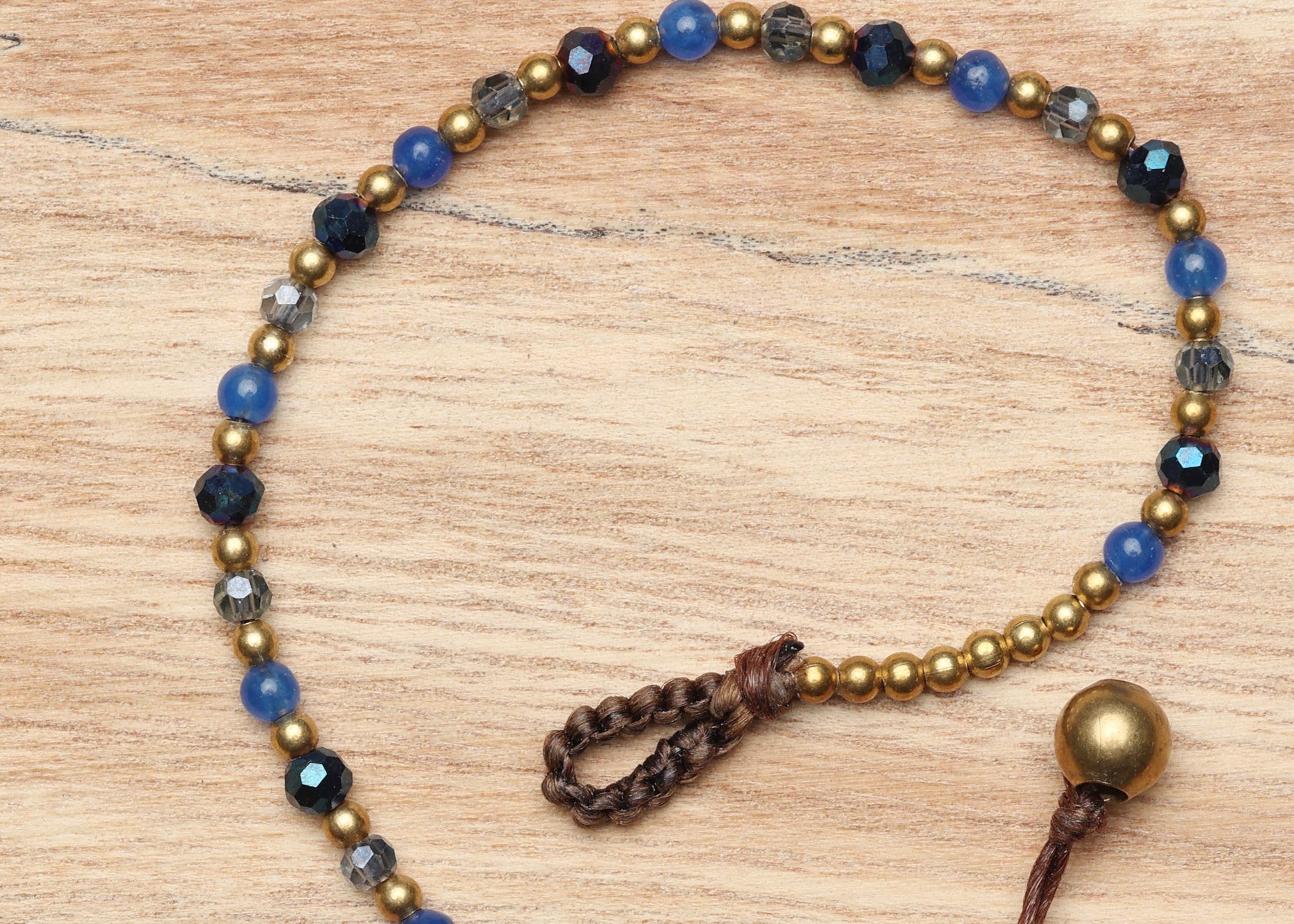 A crystal healing bracelet made of faceted Blue Agate crystals on a cotton cord with brass beads