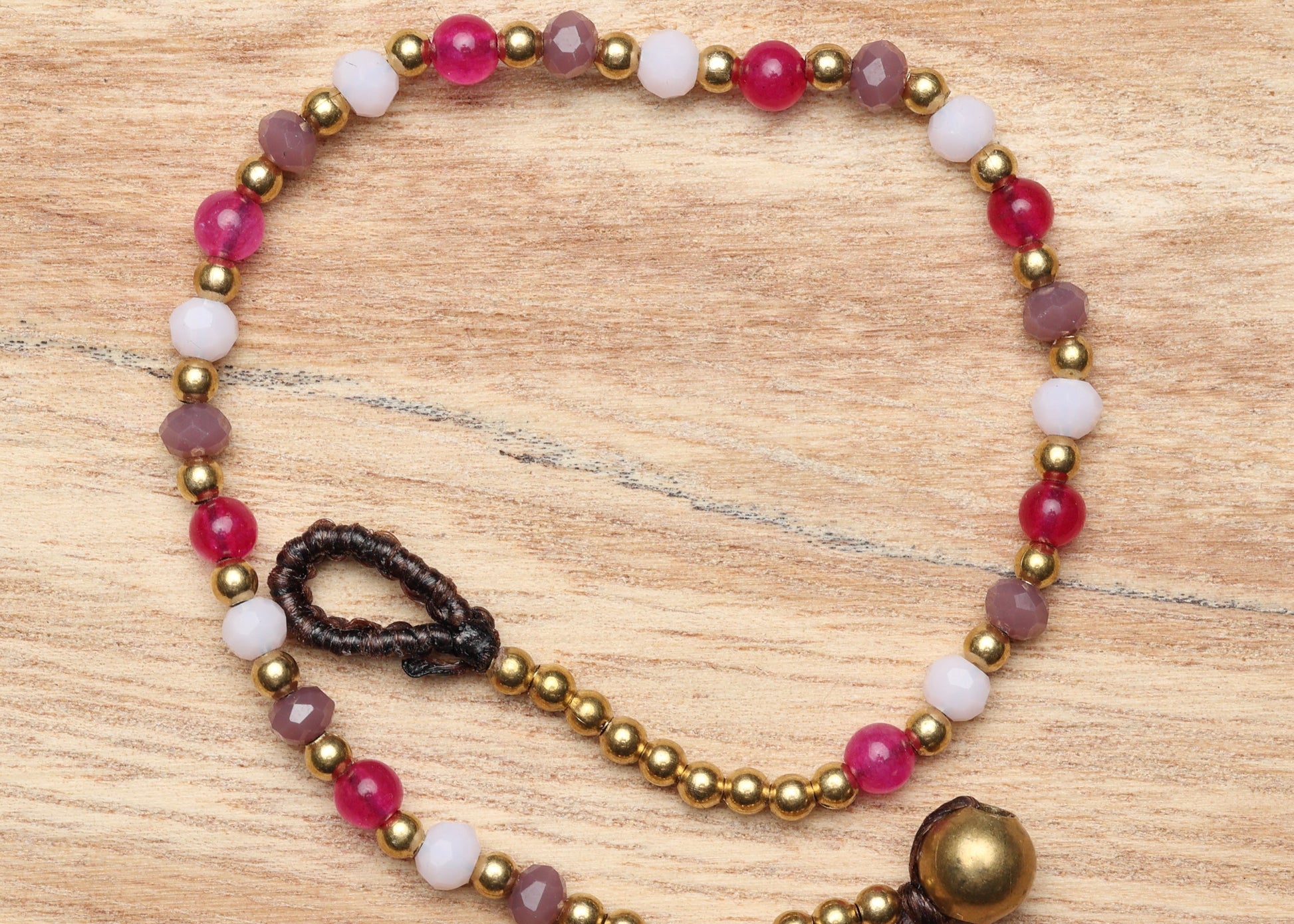 A crystal healing bracelet made of faceted Moonstone crystals on a cotton cord with brass beads